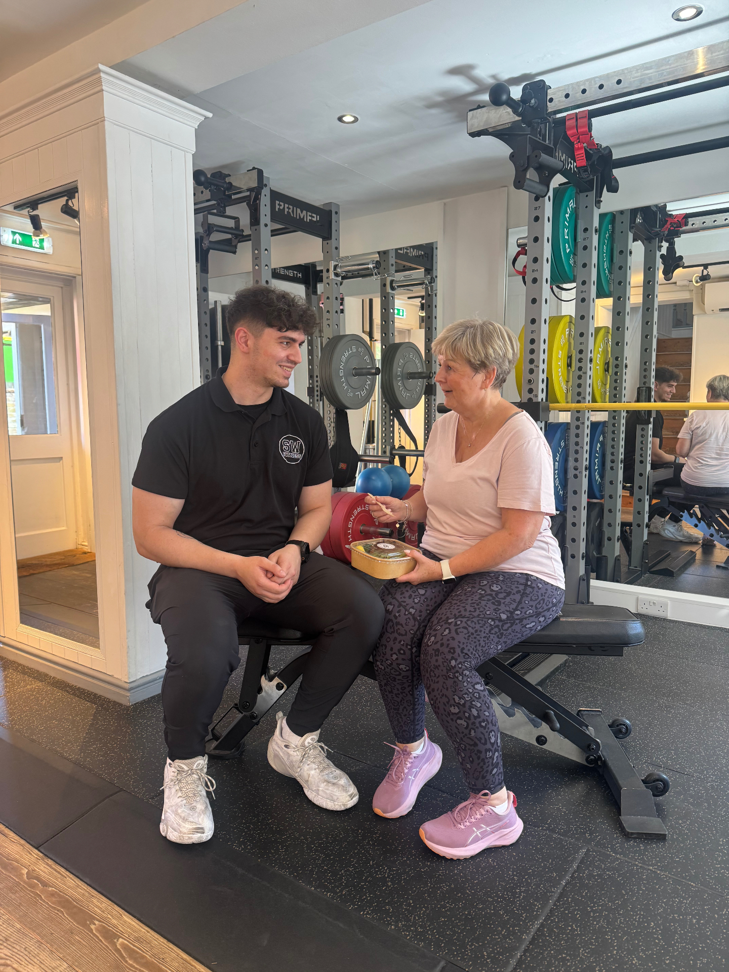Personal trainer coaching a client through a rehabilitation exercise in a private Tarporley studio